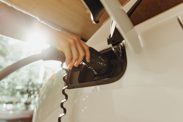Ruka umeće kabl punjača u otvor za punjenje električnog automobila